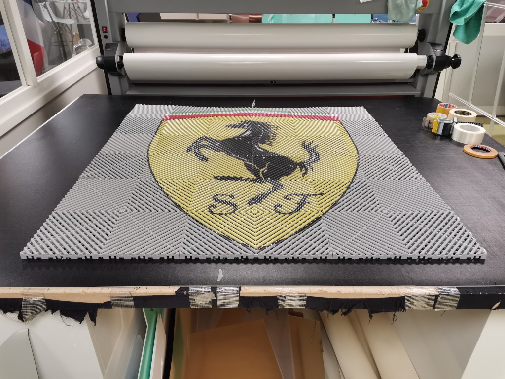 Logo Ferrari sur dalles en polypropylene gris perle effet damier 3D pour sols et décoration de garages